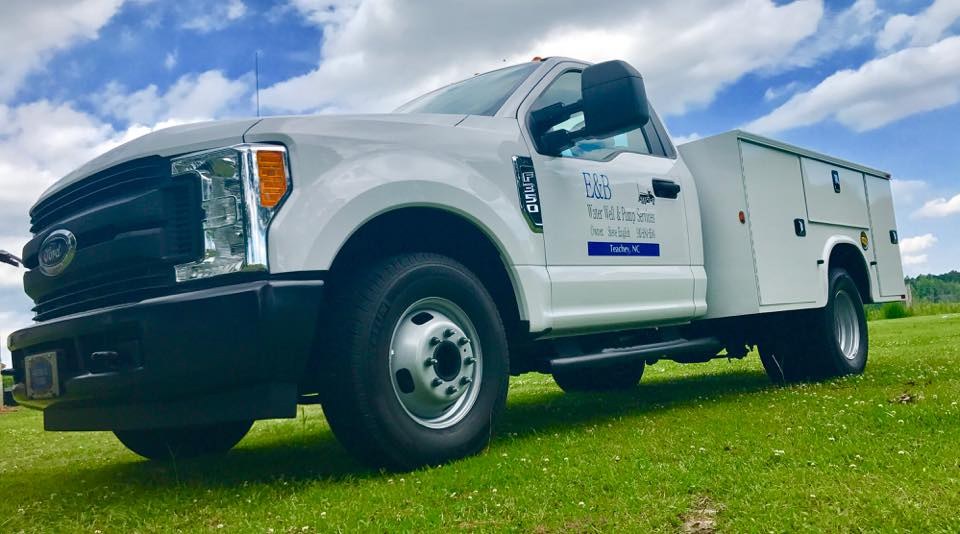 E&B Water Well and Pump Service white service truck lettered Teachey, NC, parked on grass